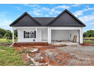 New home showcasing clean lines, an attached garage, and a front porch, awaiting final landscaping at 8455 W Nc 152 Hwy, Mooresville, NC 28115