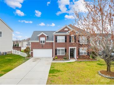 Beautiful brick home with a two-car garage, manicured lawn, and a long driveway at 10223 Kelso Ct, Charlotte, NC 28278
