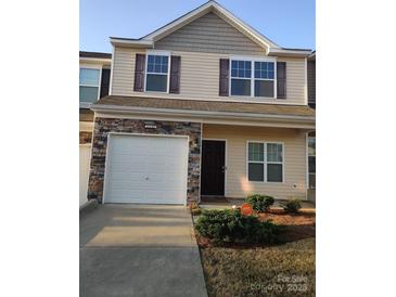 Charming two-story home featuring a one car garage, stone accents, and a welcoming dark front door at 11148 Kanturk Ct, Charlotte, NC 28213