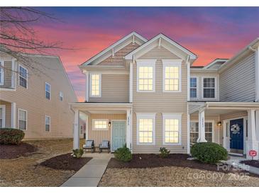 Charming two-story townhouse boasts a cozy front porch and welcoming curb appeal with meticulously maintained landscaping at 2259 Crosscut Dr, Charlotte, NC 28214