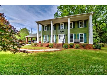 Charming two-story home featuring a well-manicured lawn and inviting front porch with classic white columns at 3400 Tracelake Dr, Matthews, NC 28105