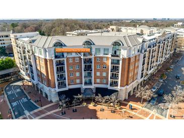 Beautiful aerial view of condo building featuring brick facade, balconies, and street view at 4620 Piedmont Row Dr, Charlotte, NC 28210