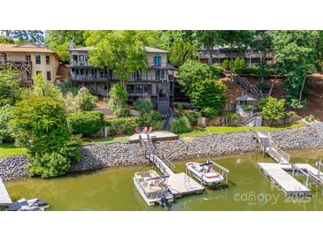 Stunning waterfront home featuring a private dock, boat lift, multiple decks, and beautifully landscaped grounds at 8014 Kiwi Pt, Tega Cay, SC 29708