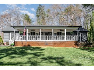 Charming home with a covered front porch, complete with rocking chairs and an American flag at 9401 Elvis Dr, Charlotte, NC 28215