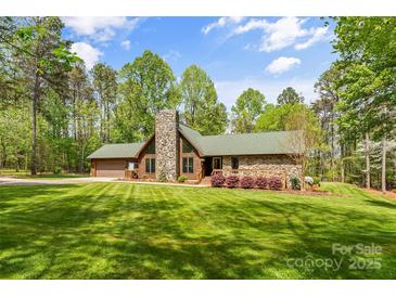 Charming stone and wood home with a stone chimney, green roof, and lush lawn at 123 Lucy Ln, Statesville, NC 28625