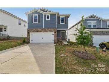 Two-story home with blue siding, brick accents, white garage door, and well-maintained landscaping at 1305 31St Ne St, Conover, NC 28613