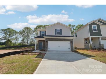 Charming two-story home featuring a two-car garage, brick accents, and blue shutters at 1466 31St Ne St, Conover, NC 28613