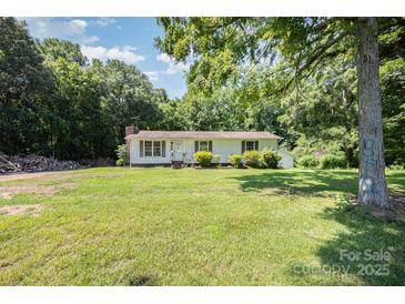 Charming single-story home featuring a welcoming front yard, complemented by mature trees and simple landscaping at 5275 Long Ferry Rd, Salisbury, NC 28146