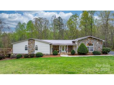 Charming ranch home featuring stone accents, a metal roof, and a well-manicured lawn and landscaping at 1514 Ring Tail Rd, Claremont, NC 28610