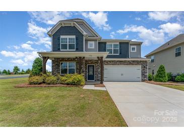 Charming two-story home boasts stone accents, a two-car garage, and a well-manicured front yard at 1766 Loggerhead Dr, Lancaster, SC 29720