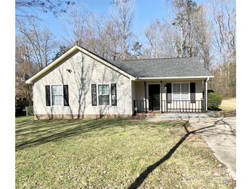 Charming one-story home with a well-maintained lawn, black shutters, and a cozy front porch at 218 Cottonwood Park Dr, Charlotte, NC 28214
