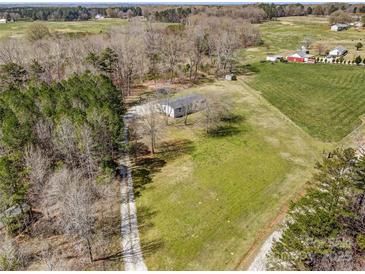 An aerial view displays the property with green space, a tree line and surrounding rural landscape at 260 Charlie Stacks Rd, Lancaster, SC 29720