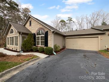 Charming home with stone accents, a well-maintained yard, and an attached garage at 2905 Polo View Ln, Matthews, NC 28105
