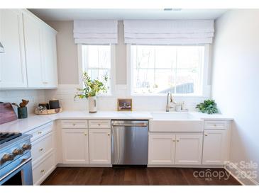 Bright kitchen features white cabinetry, stainless steel appliances, subway tile backsplash, and a farmhouse sink at 403 Old Town Village Rd, Waxhaw, NC 28173