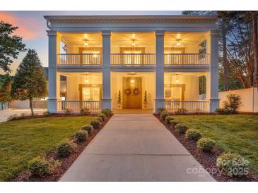 Stately two-story home with a welcoming double-decker front porch and manicured lawn at 8150 Malibu Pointe Ln, Denver, NC 28037
