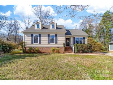 Charming one-story home with well-maintained lawn and inviting front entrance with dark shutters and colorful front door decor at 9624 Buckskin Ln, Mint Hill, NC 28227