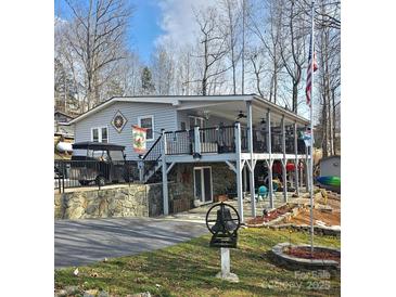 Charming home featuring a spacious porch, stone accents, well-manicured lawn and an American flag at 112 Trestle Cir, New London, NC 28127