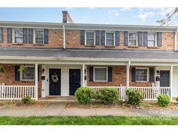 Charming brick townhomes featuring black shutters and inviting covered front porches at 1310 Green Oaks Ln # H, Charlotte, NC 28205