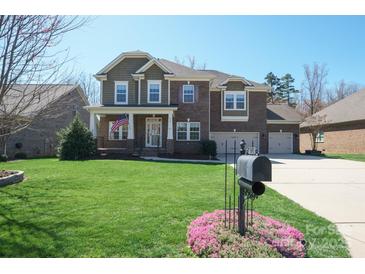 Beautiful brick home with a three-car garage, well-manicured lawn, and charming front porch at 224 Alexandria Dr, Mooresville, NC 28115