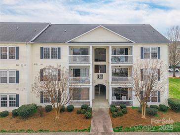 Inviting condo with private balconies, landscaped grounds, and a charming walkway to the entrance at 3960 Town Center Rd, Harrisburg, NC 28075