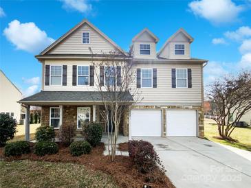 Charming two-story home with a two-car garage and manicured landscaping under a bright blue sky at 5006 Brodie Ln, Fort Mill, SC 29707