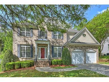 Charming two-story brick home with a manicured lawn and a two-car attached garage at 6008 Nuthatch Ct, Charlotte, NC 28277