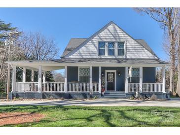 Charming blue two-story home featuring a welcoming porch and a well-manicured front lawn at 704 N Main Ave, Newton, NC 28658