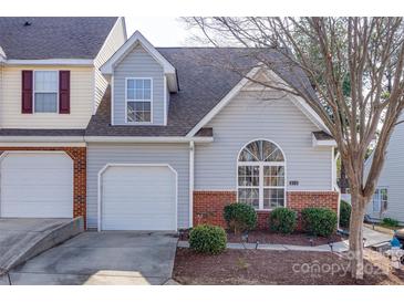 Charming townhome with light gray siding, brick accents, well-manicured landscaping, and an attached one-car garage at 810 Rock Lake Gln, Fort Mill, SC 29715