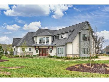 An impressive exterior view of a modern farmhouse-style home with a manicured lawn at 101 S Shore Dr, Belmont, NC 28012