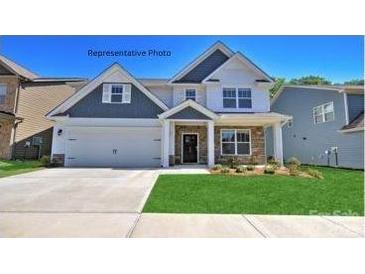Charming two-story home with a manicured lawn, a two-car garage, and lovely stone detailing at 116 Asmodean Ln, Troutman, NC 28166