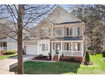 Charming two-story home with a covered front porch and well-maintained lawn and an attached garage at 15124 Hugh Mcauley Rd, Huntersville, NC 28078