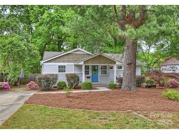 Charming home featuring a blue door, brick foundation, and mature landscaping in a desirable neighborhood at 1837 Academy St, Charlotte, NC 28205