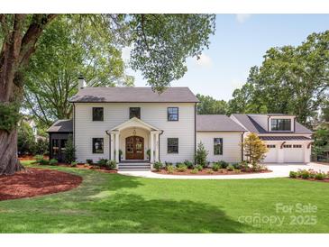 Stunning two-story home featuring a manicured lawn, double door entry, and a charming facade at 401 Woodland St, Davidson, NC 28036