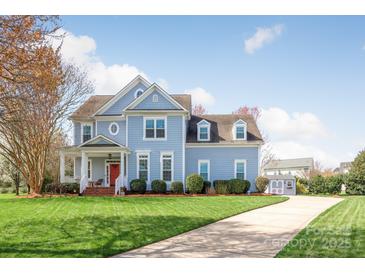 Charming two-story home featuring a welcoming porch, manicured lawn, and beautiful landscaping at 5601 Underwood Ave, Charlotte, NC 28213