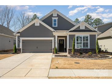 Charming single Gathering home featuring gray siding, well-kept landscaping, and an attached two-car garage at 7056 Cornwallis Ct, Iron Station, NC 28080