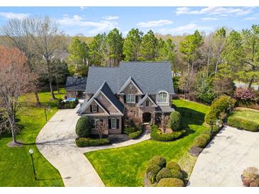 A grand brick home with a circular driveway and lush landscaping, creating an inviting curb appeal at 9101 Clerkenwell Dr, Waxhaw, NC 28173