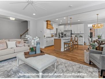 Bright open-concept living room and kitchen area with hardwood floors and modern finishes at 19728-A School St, Cornelius, NC 28031