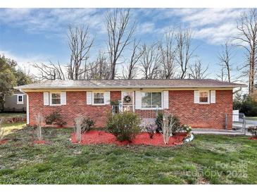 Charming brick home featuring a manicured lawn and inviting entryway with decorative touches at 213 Turner Rd, Gastonia, NC 28056