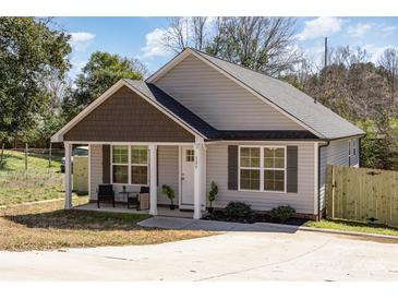 Charming single-story home with a covered porch and nicely landscaped front yard at 329 Gurley Nw Dr, Concord, NC 28027