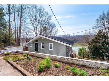 Charming exterior view of lake house with water view, flower beds, and lovely yard at 4846 Midway Sand Rd, Hickory, NC 28601