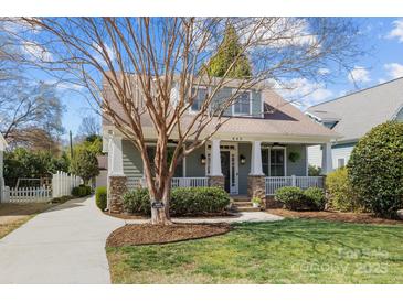 Inviting home showcasing a charming porch, stone accents, manicured lawn, and beautiful landscaping at 643 Mcalway Rd, Charlotte, NC 28211