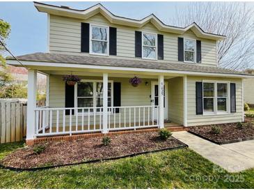 Charming two-story home featuring a welcoming front porch with decorative hanging flower baskets at 7025 Spring Morning Ln, Charlotte, NC 28227