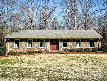 Charming brick home featuring green shutters, a manicured lawn, and a welcoming entrance at 925 Belmorrow Dr, Charlotte, NC 28214