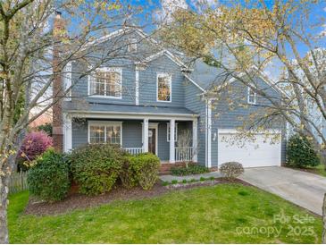 Charming two-story home with a covered front porch, attached garage, and professionally landscaped yard at 10105 Bon Meade Ln, Cornelius, NC 28031