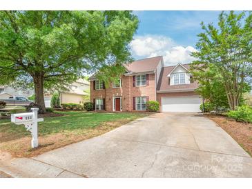 Charming two-story brick home featuring a well-manicured lawn and a long driveway at 111 Harris Farm Rd, Mooresville, NC 28115