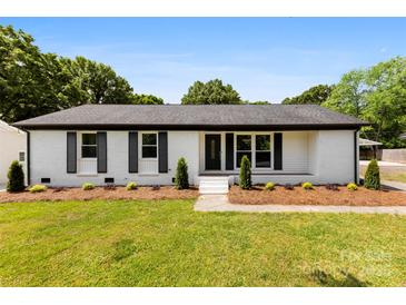 Charming single-story home featuring a well-maintained lawn and a classic white brick facade with black shutters at 1316 Fox Run Dr, Charlotte, NC 28212
