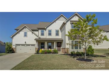 Charming two-story home featuring a neutral color palette, well-manicured lawn, and an attached two-car garage at 14229 Twin Eagles Ln, Charlotte, NC 28278