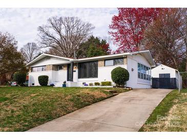 Charming home featuring a brick and white facade with a well-manicured lawn and mature trees at 1621 Keeling Pl, Charlotte, NC 28210