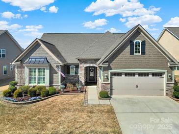 Charming home featuring stone accents, a manicured front yard, and an attached two car garage at 3097 Arches Bluff Cir, Lancaster, SC 29720