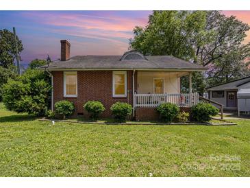 Charming brick home featuring a cozy front porch and well-manicured landscaping in a beautiful neighborhood at 404 E 1St St, Cherryville, NC 28021